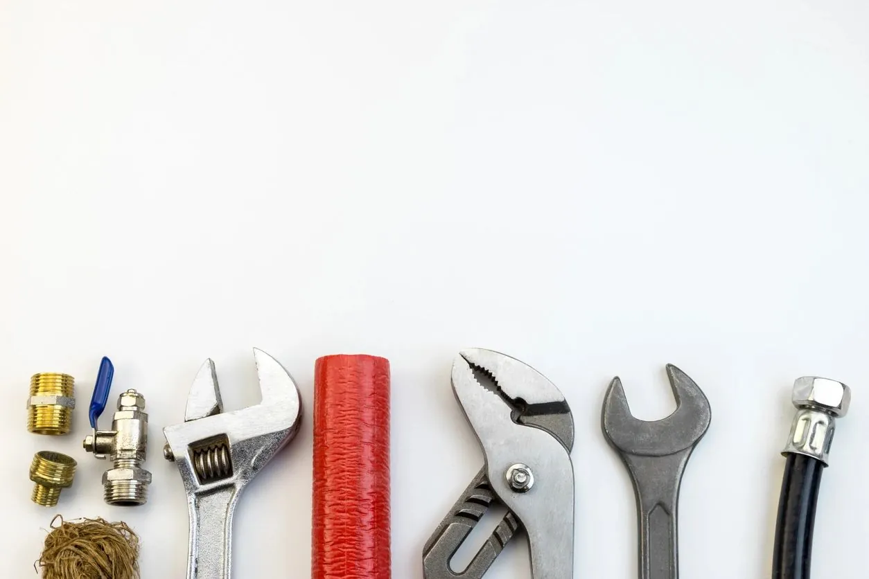Professional plumbing tools including wrenches, pipes and fittings