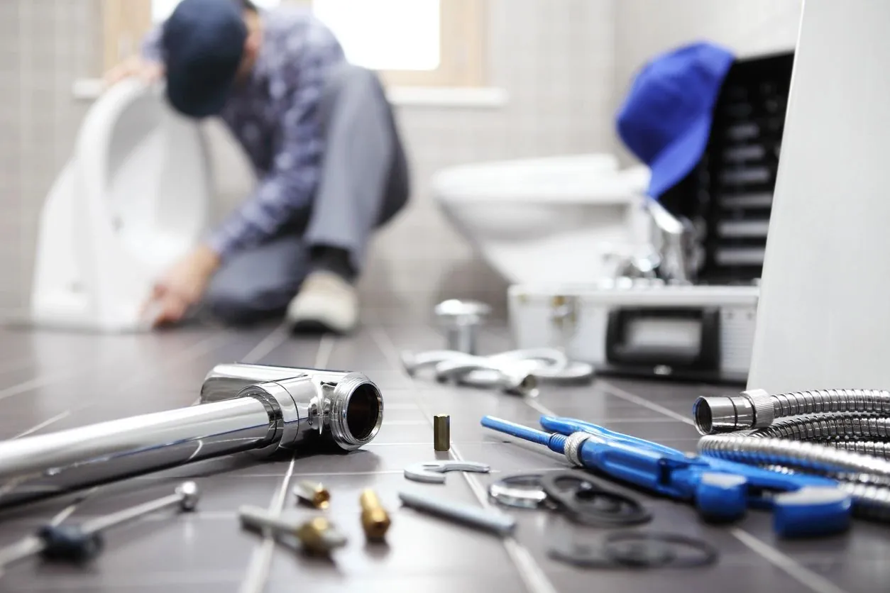 Jake and Jim's plumber installing bathroom fixtures with professional tools
